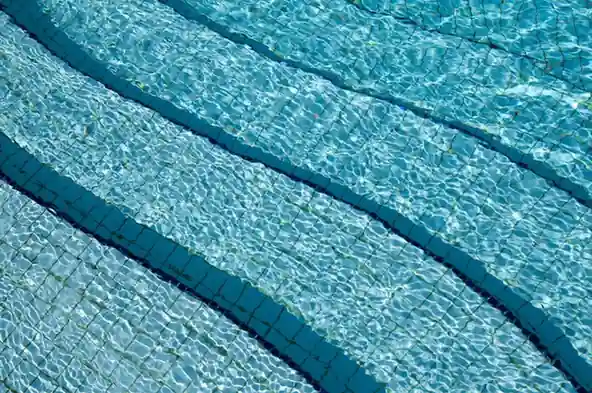 陽光にきらめく澄んだ青いプールの水面のクローズアップ