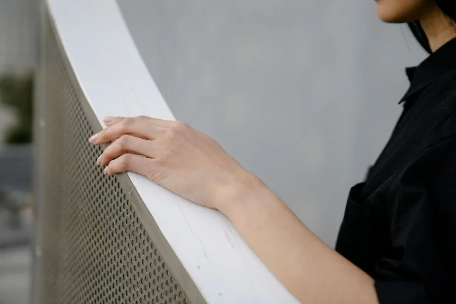 A hand resting against a textured wall, fingers spread to feel the surface