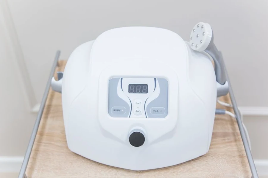 A compact aesthetic device on a treatment cart in a clinic room