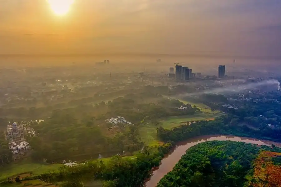 A hazy, sunlit view over a tropical city skyline
