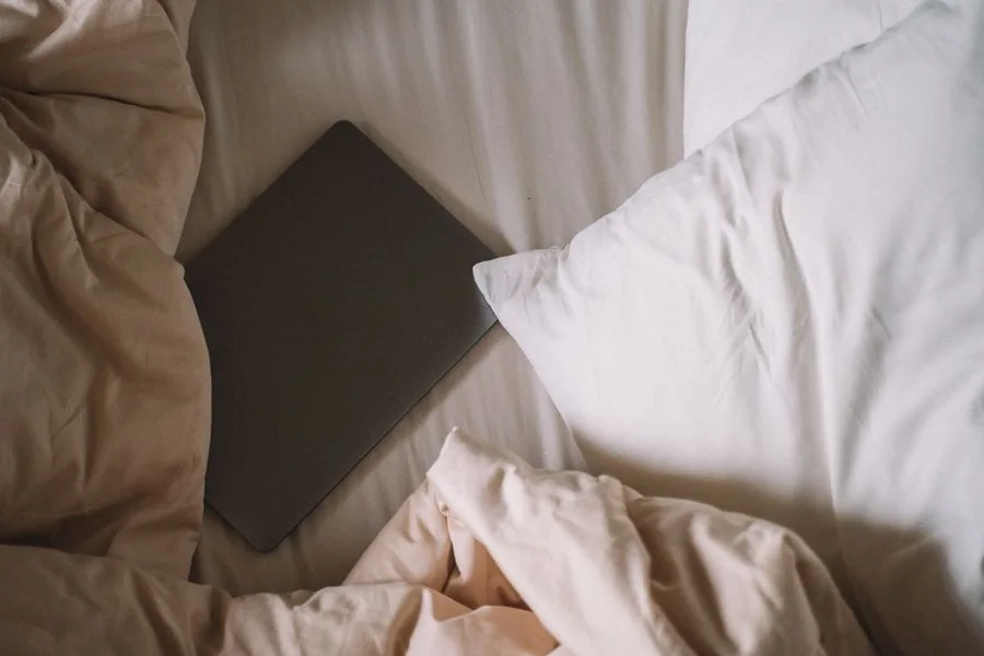 Stacked white pillows arranged on a bed for elevated recovery sleep