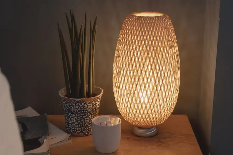 Warm bedside lamp glowing softly on a wooden nightstand in the evening