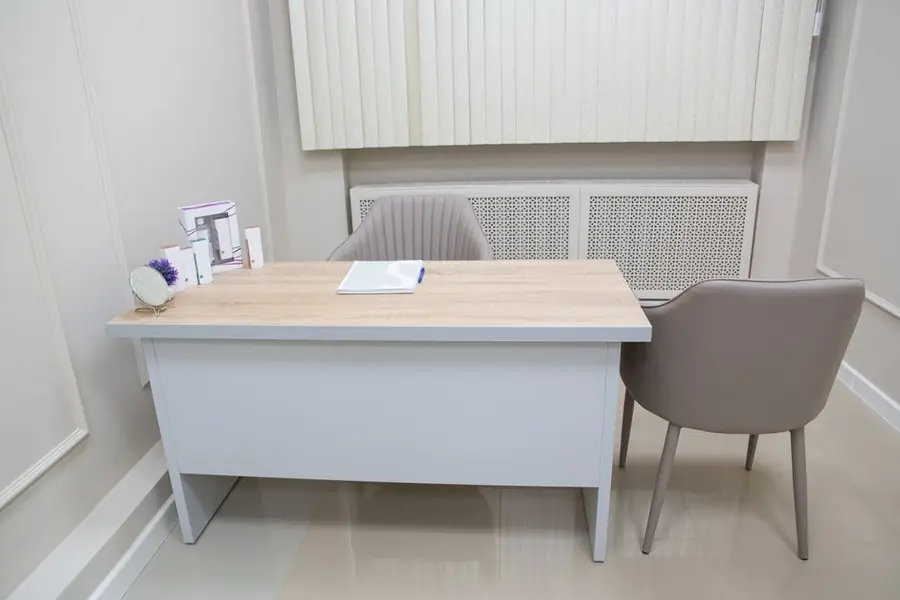 A calm consultation room with a desk and two chairs in a Kuala Lumpur clinic