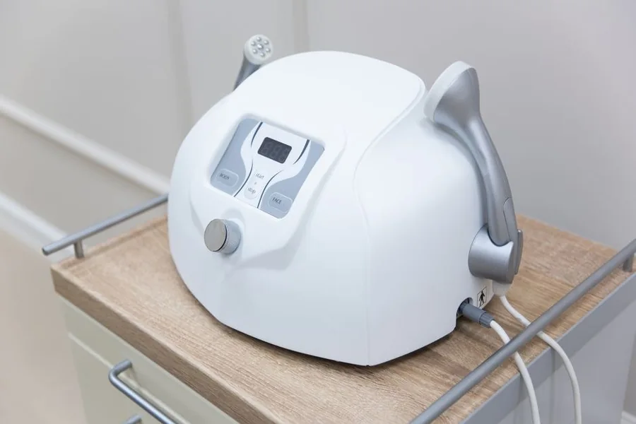 現代的なクリニックの施術室でカートの上に置かれたボディスカルプティング機器